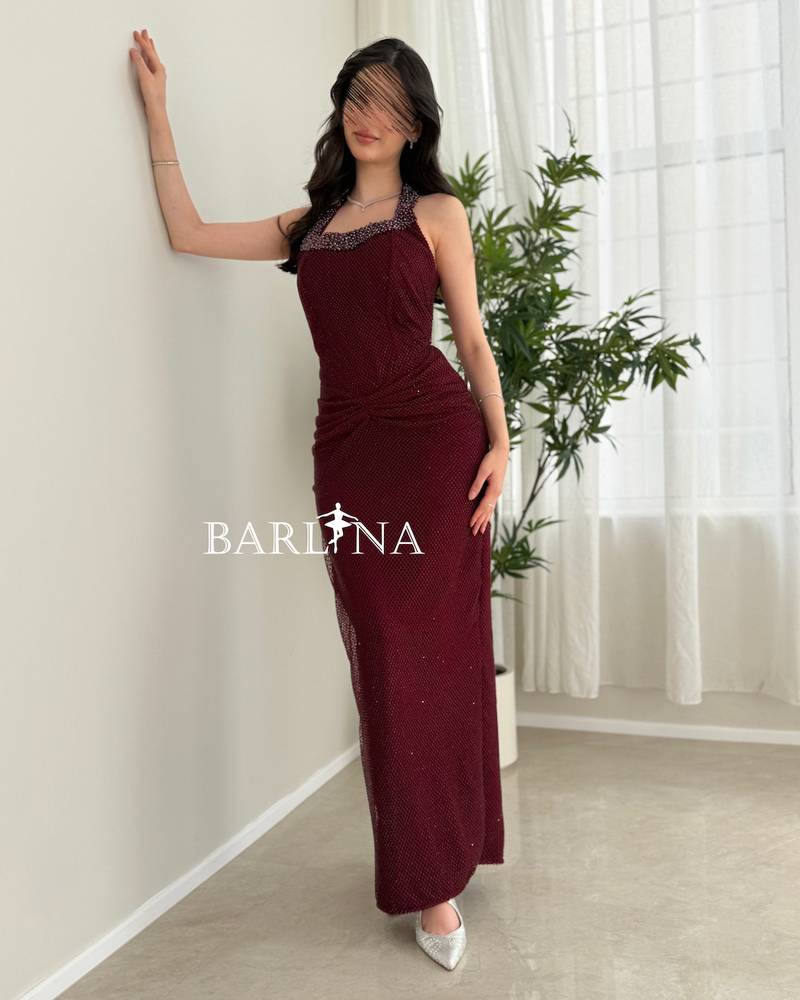 A long, elegant burgundy halter-neck dress
