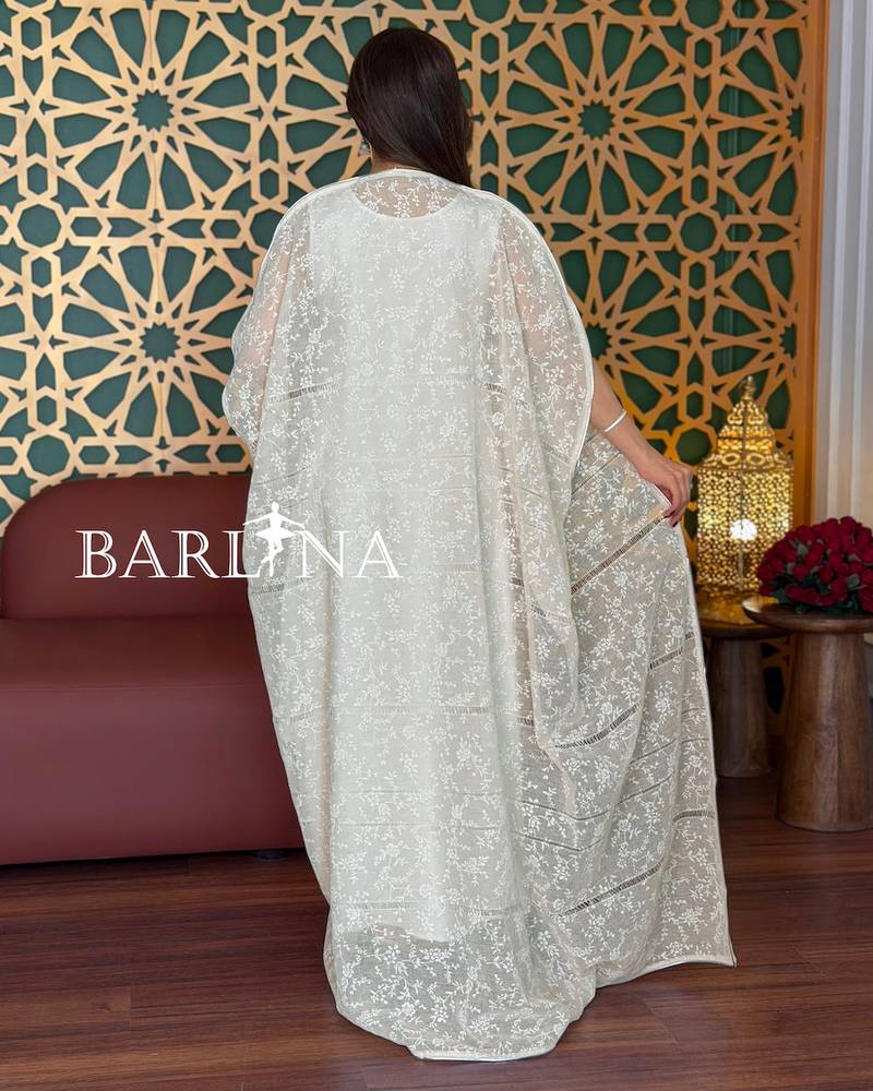 A soft white jalabiya with a sheer lace overlay.