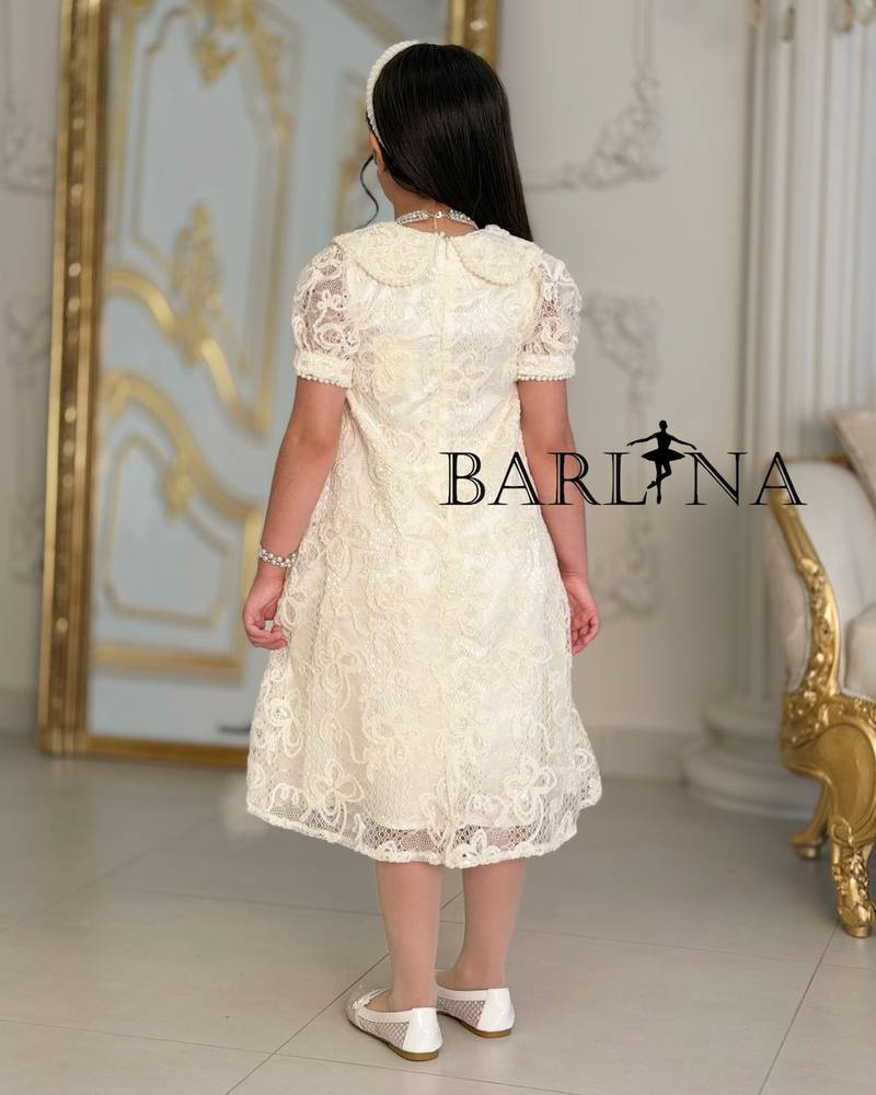 A soft girl's dress with lace and feather trim