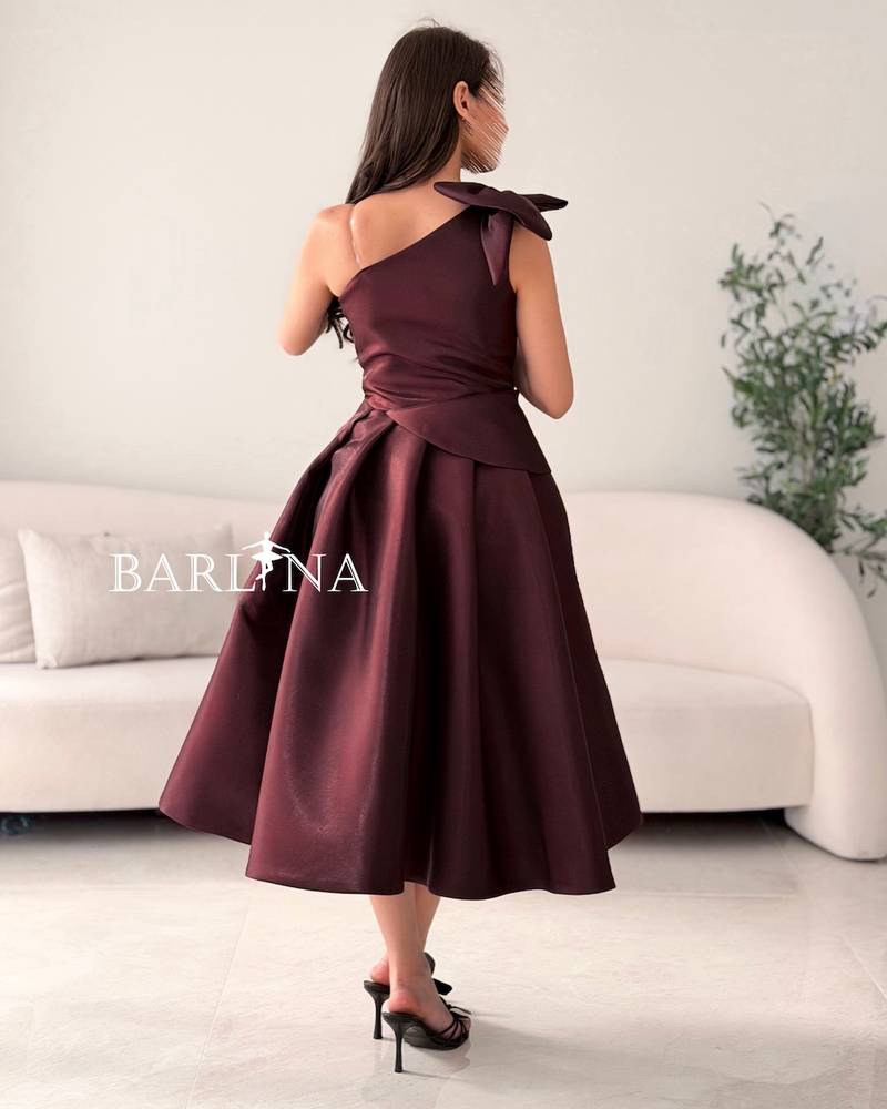 One-shoulder brown dress with a large gold rose