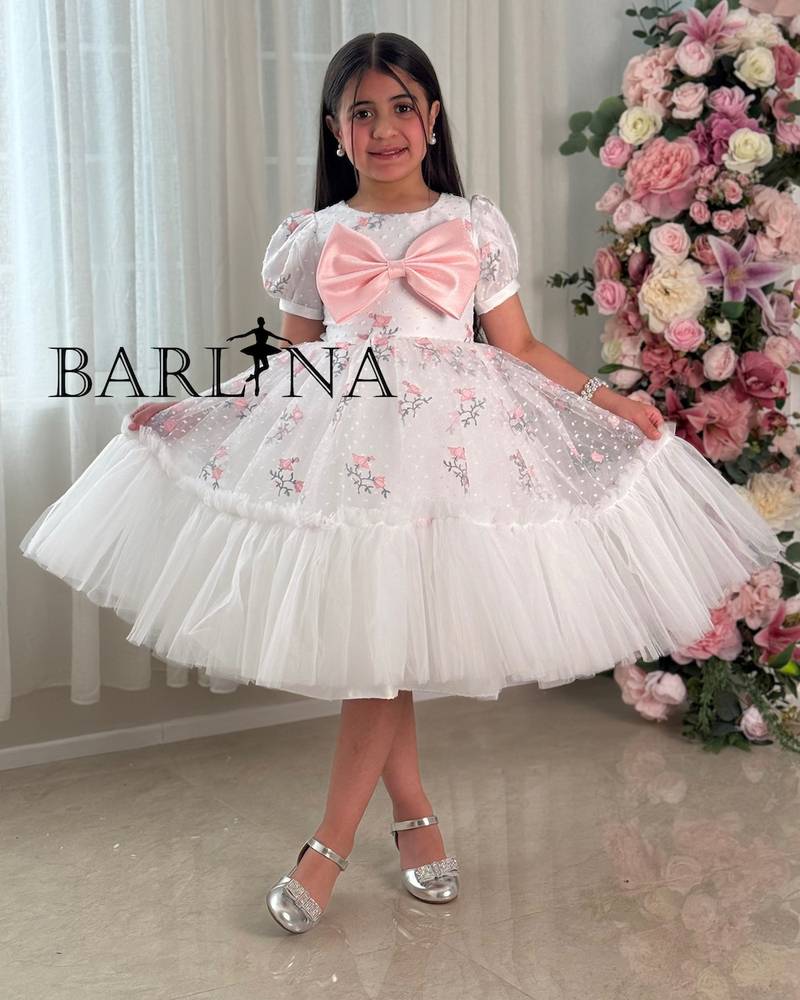 White girl's dress with embroidery and a pink flower