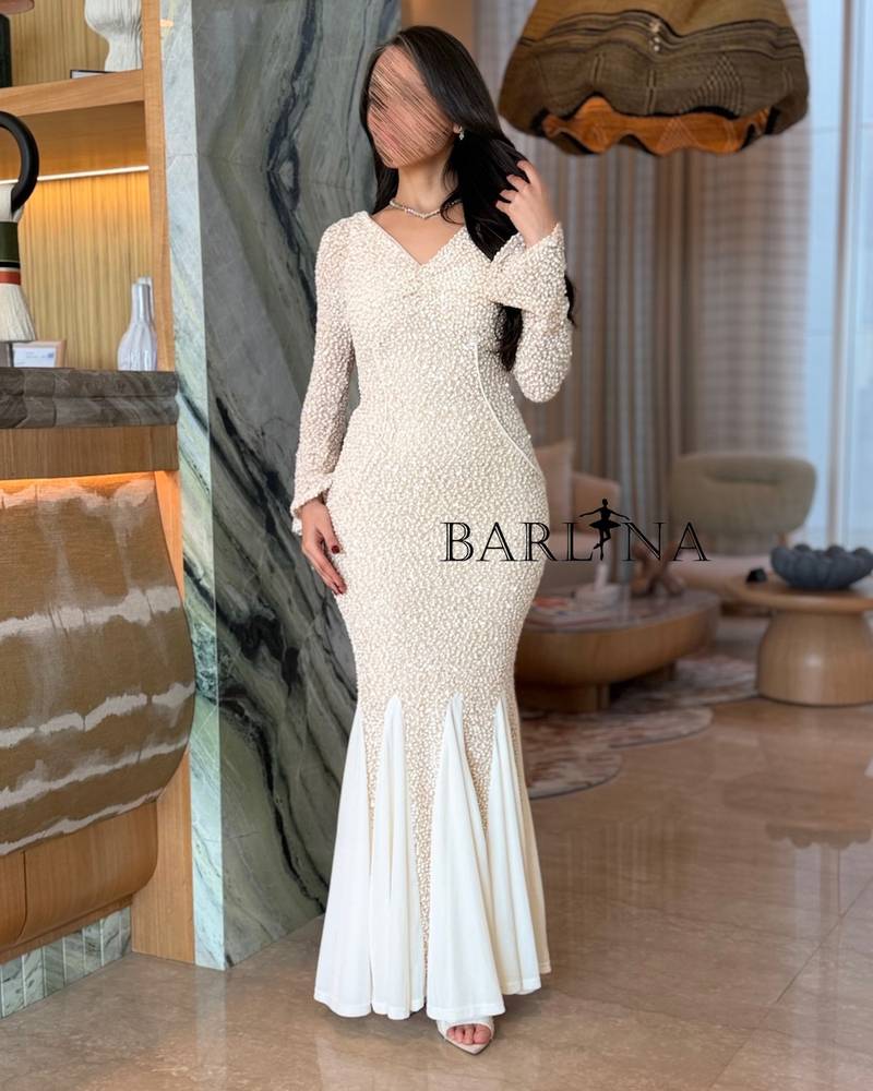 A fitted off-white dress with a flowing mermaid silhouette