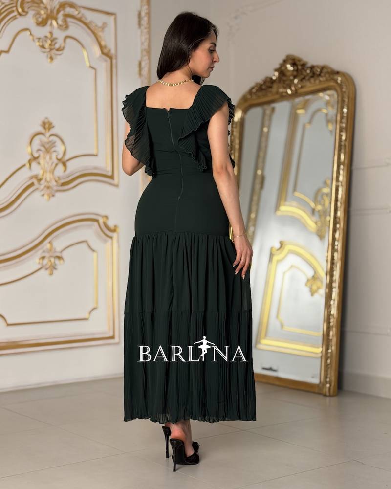 Long green dress with pleats and ruffled sleeves