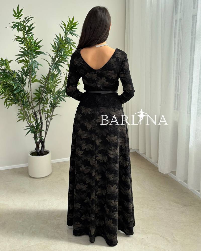A soft black dress with a subtle pattern and a thin belt