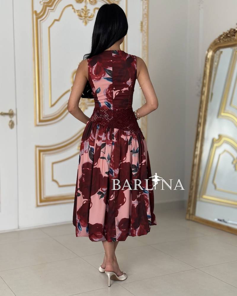 A stylish pink dress with red floral accents