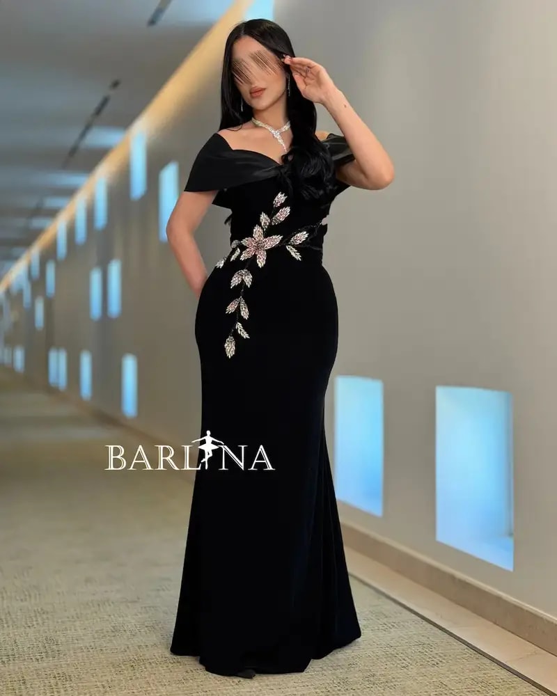 A black dress with a soft cut adorned with shimmering roses.
