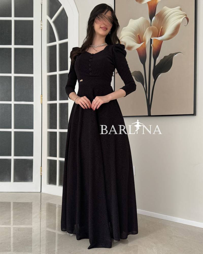A black dress with a wide cut and elegant buttons