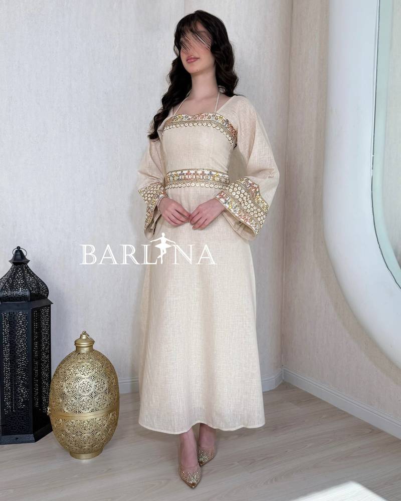 A soft beige jalabiya decorated with gold embroidery