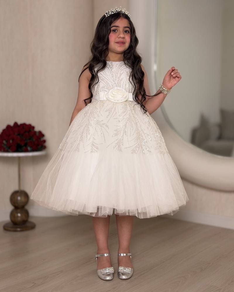 White girl's dress decorated with glitter patterns and a belt