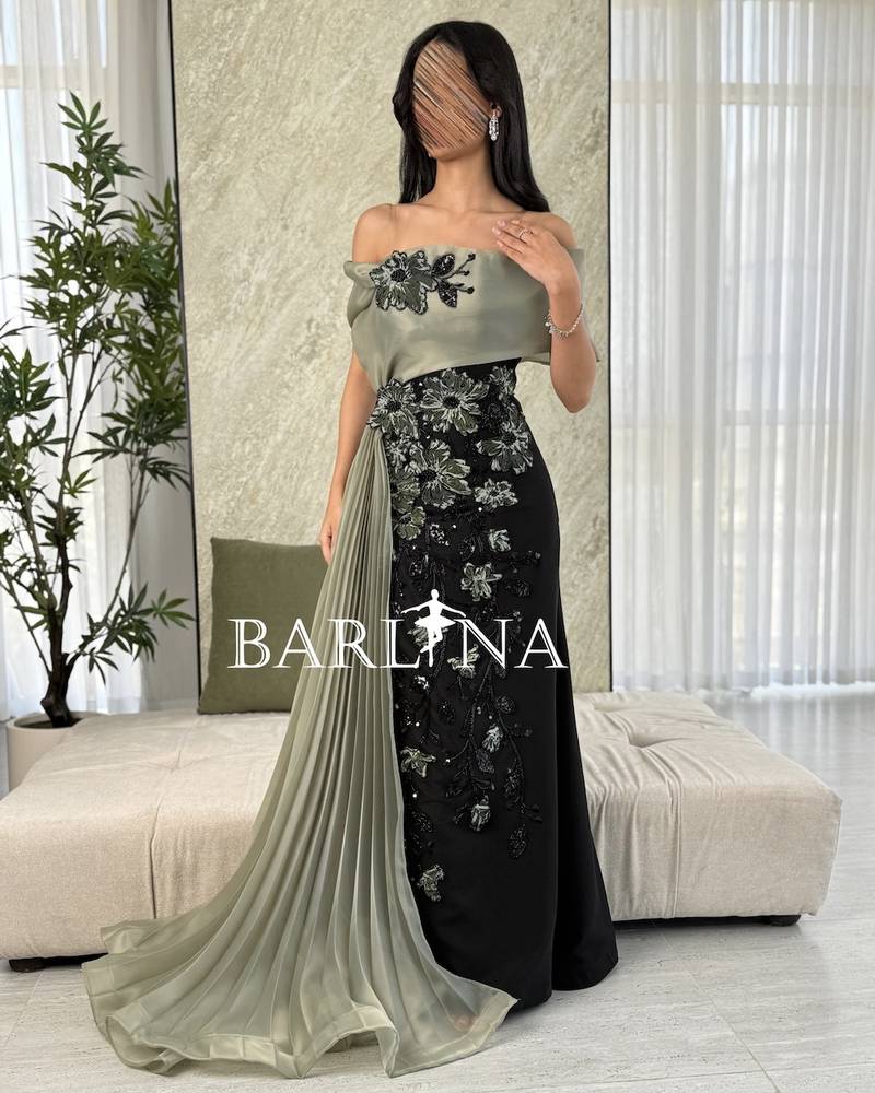 Black dress with an olive top and pleated tail