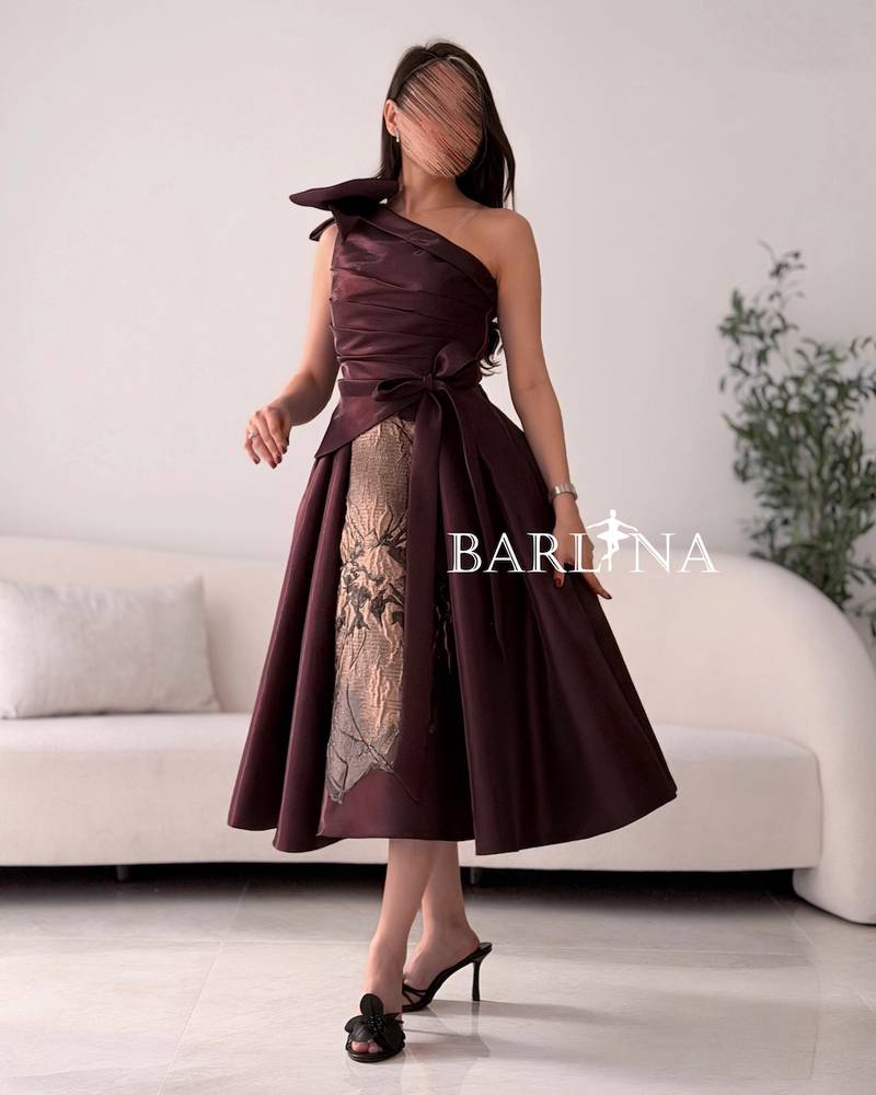 One-shoulder brown dress with a large gold rose