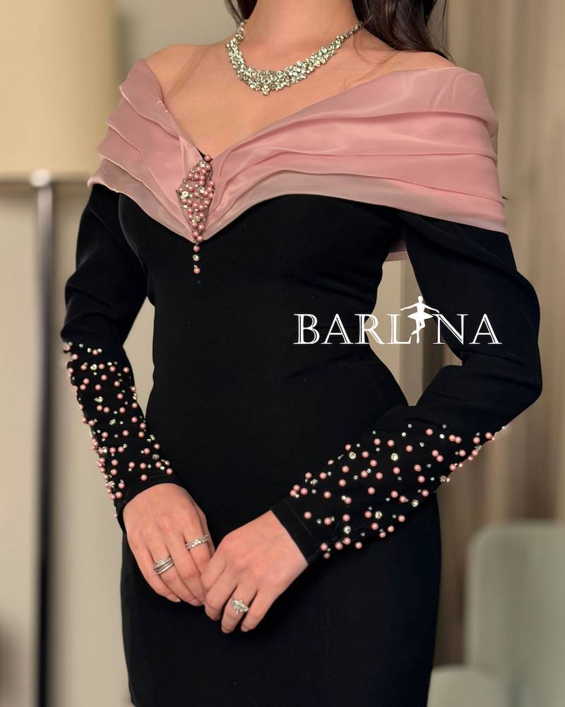 A black dress with pink details and elegant ruffles