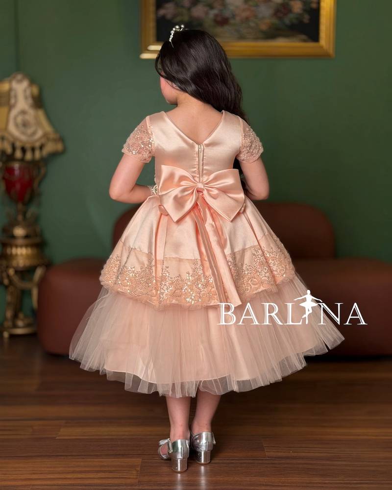 Girls' dress in a peach color with short sheer sleeves
