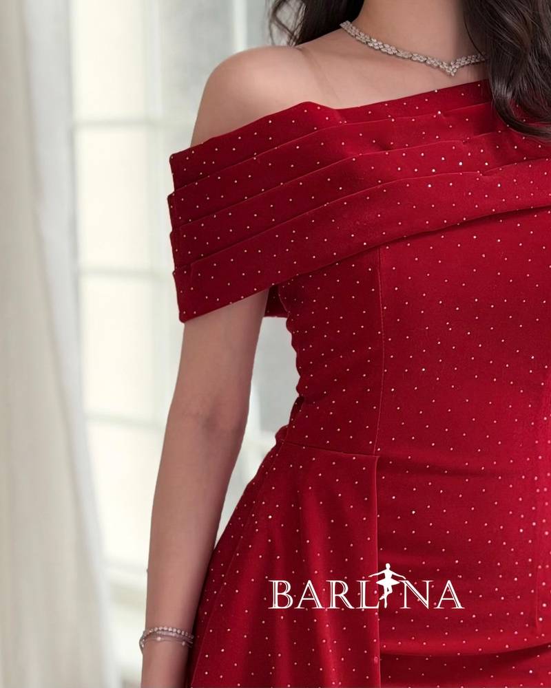 Red dress adorned with small rhinestones and a side train
