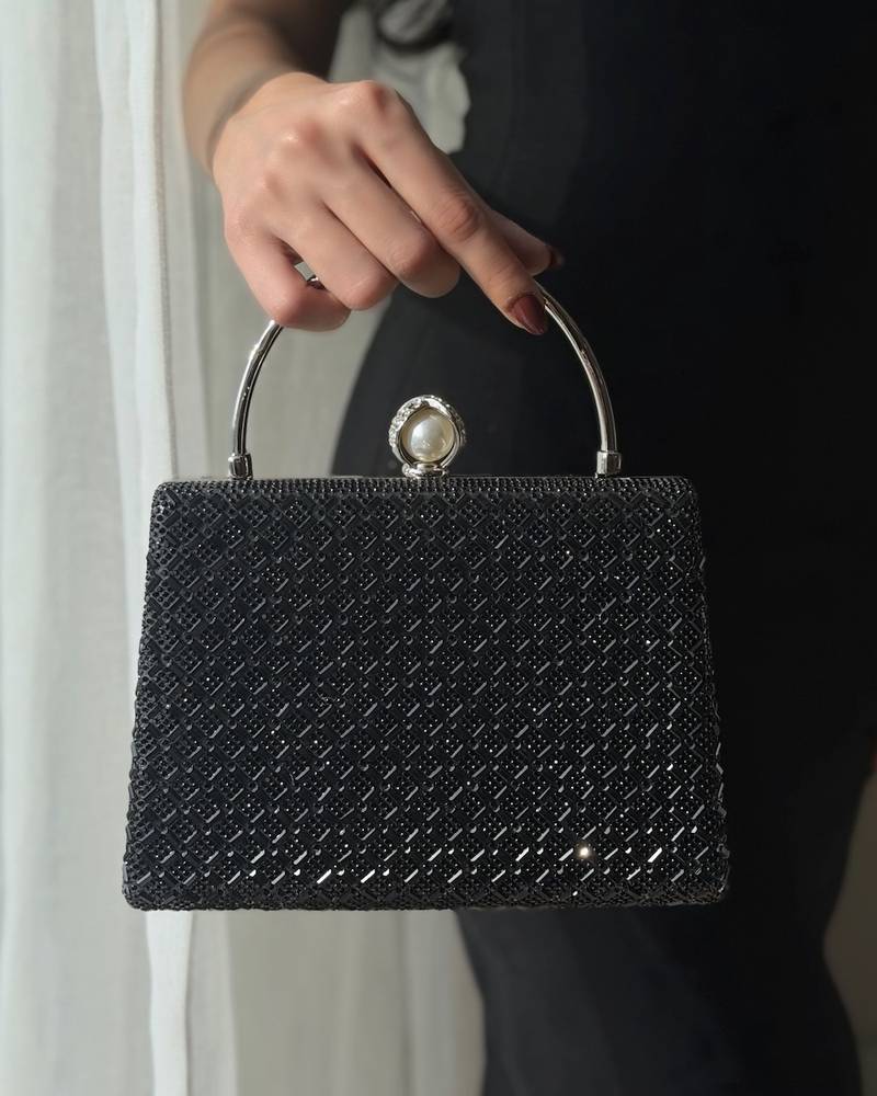 Evening bag with a round handle decorated with a pearl