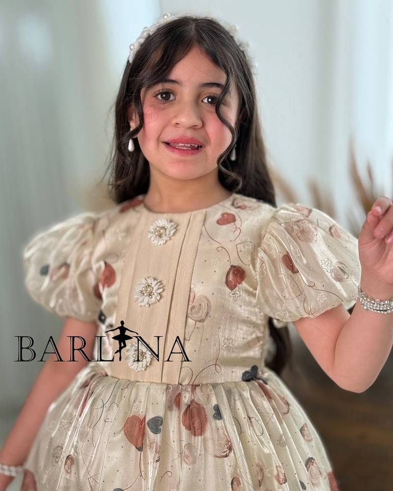 Beige girls' dress decorated with a heart print