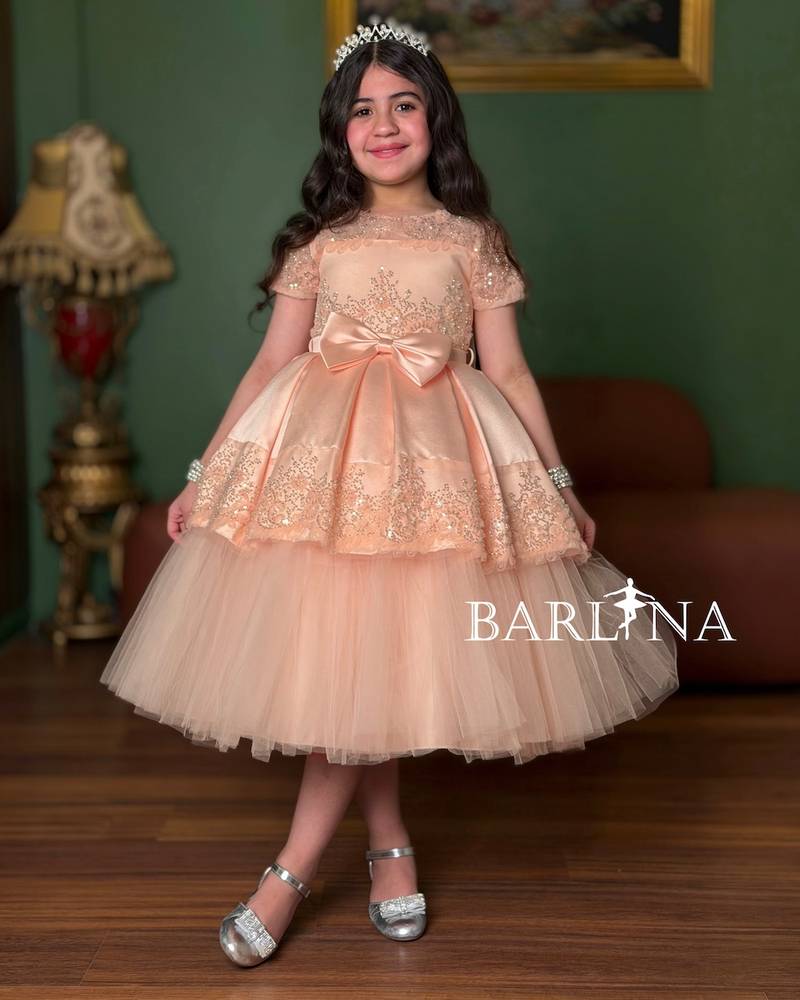 Girls' dress in a peach color with short sheer sleeves