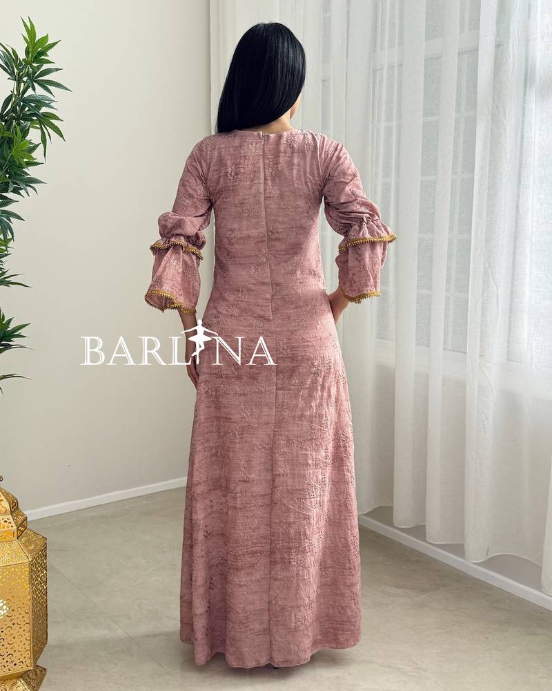 A soft pink jalabiya with gold trim