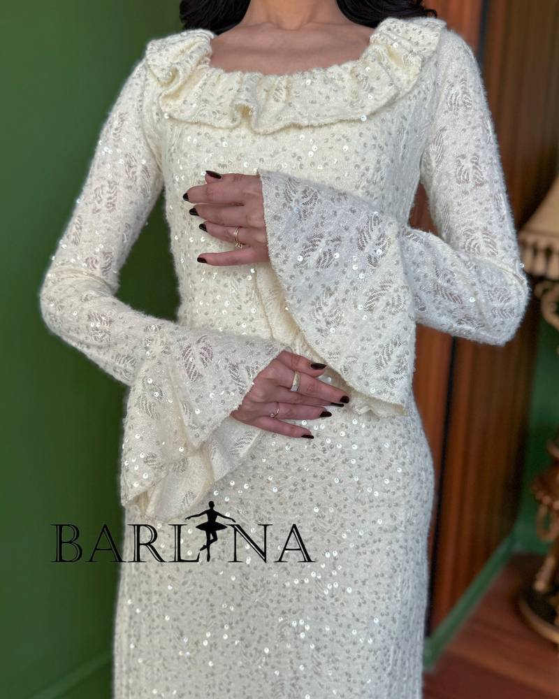 An ivory dress adorned with embroidery and shimmering details.