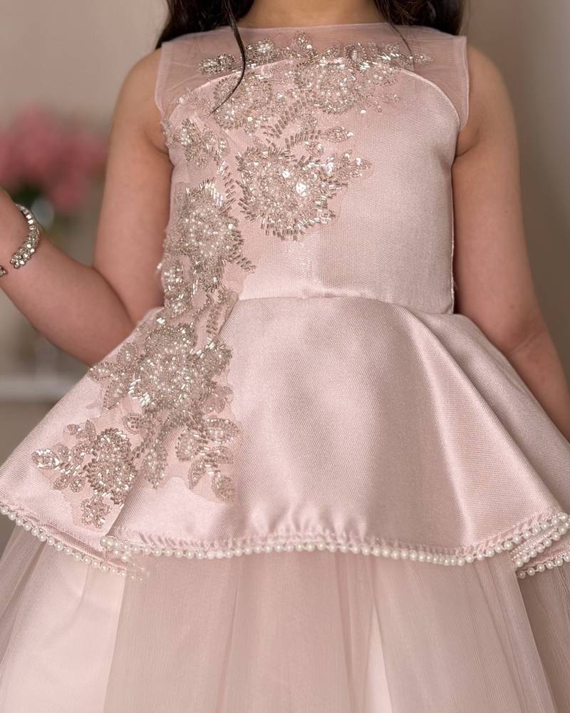 Pink girl's dress decorated with sparkly embroidery