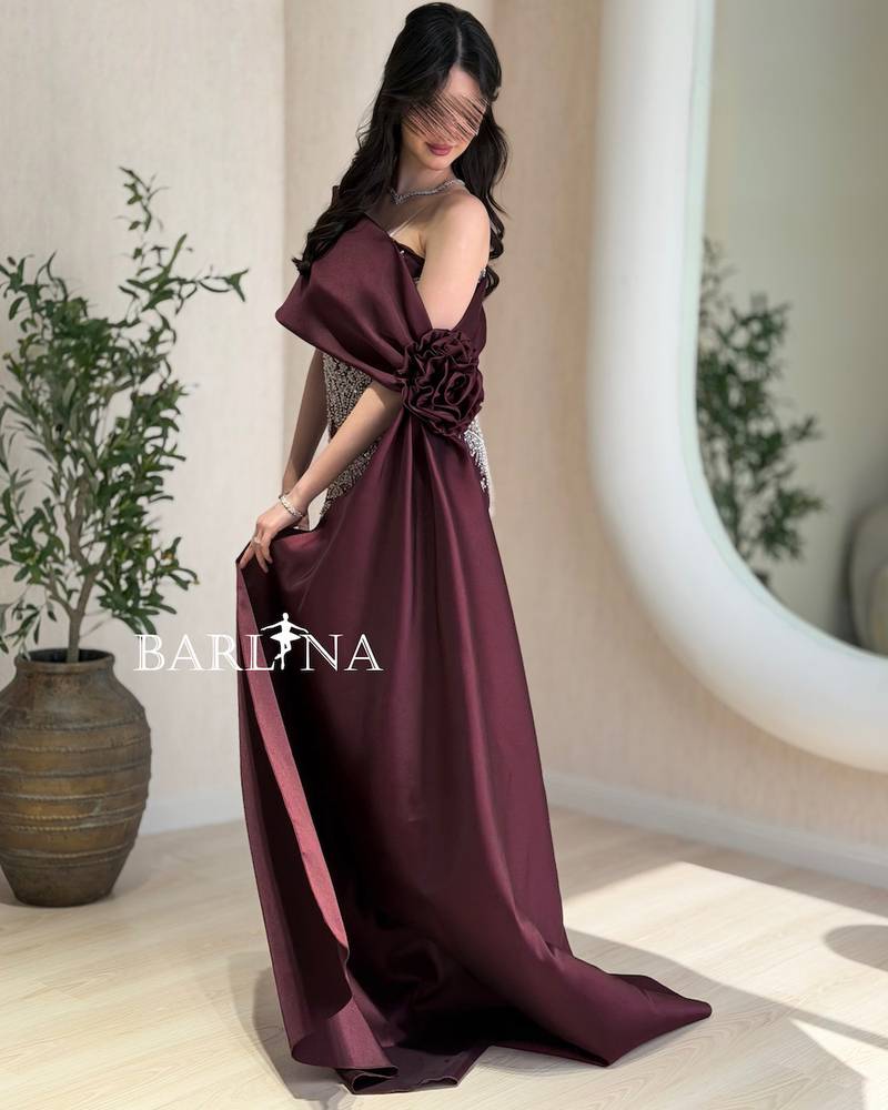 A burgundy dress with silver embroidery and a matching train.