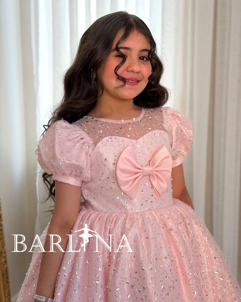 A shiny pink girl's dress decorated with sparkly details
