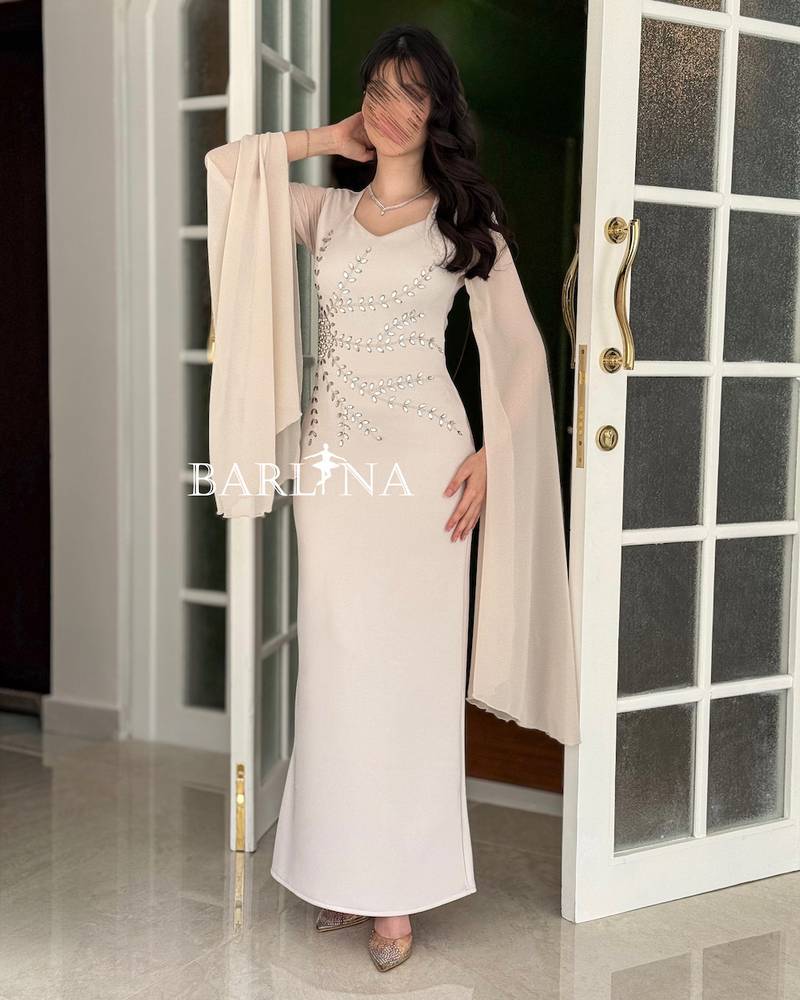 A soft off-white dress adorned with crystal embroidery