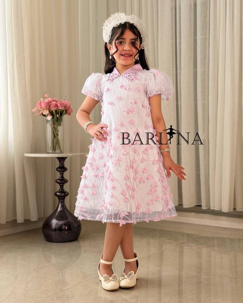 Elegant pink girl's dress decorated with roses