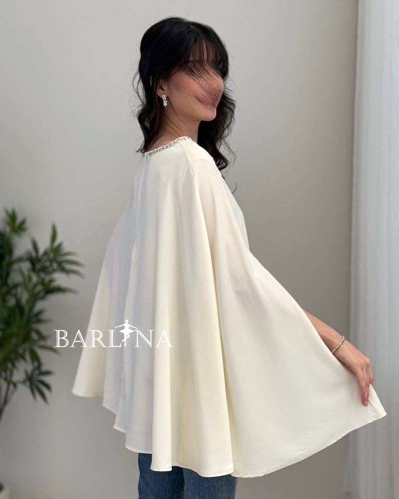 A soft blouse adorned with a pearl trim