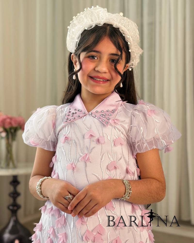 Elegant pink girl's dress decorated with roses