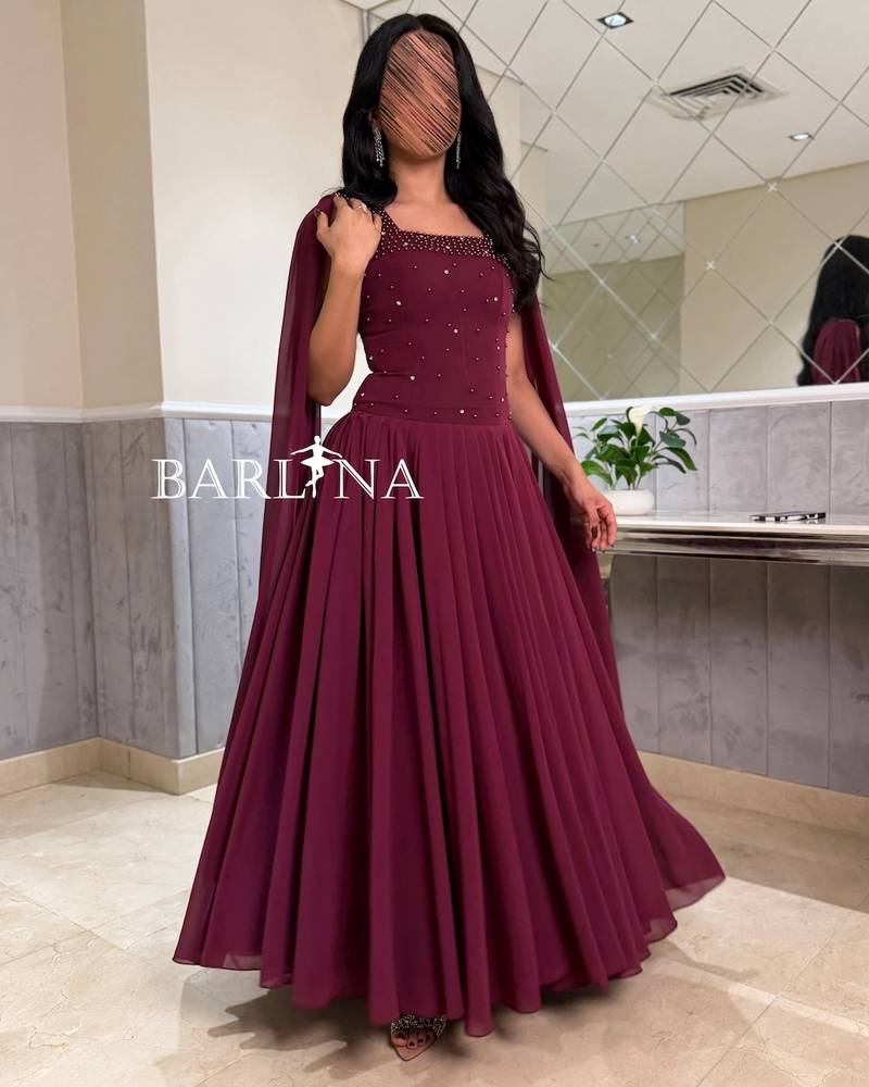 A flowy berry-colored dress with a royal long cape