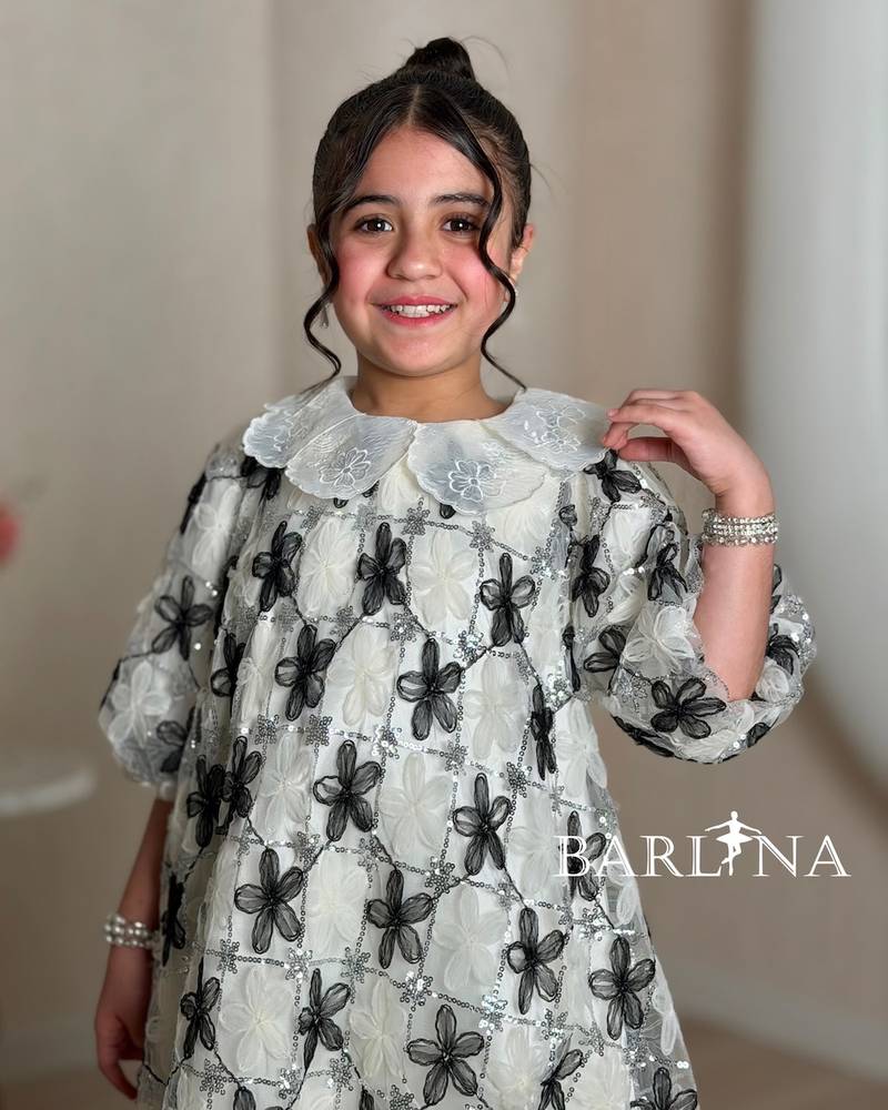 Off-white girl's dress decorated with black roses
