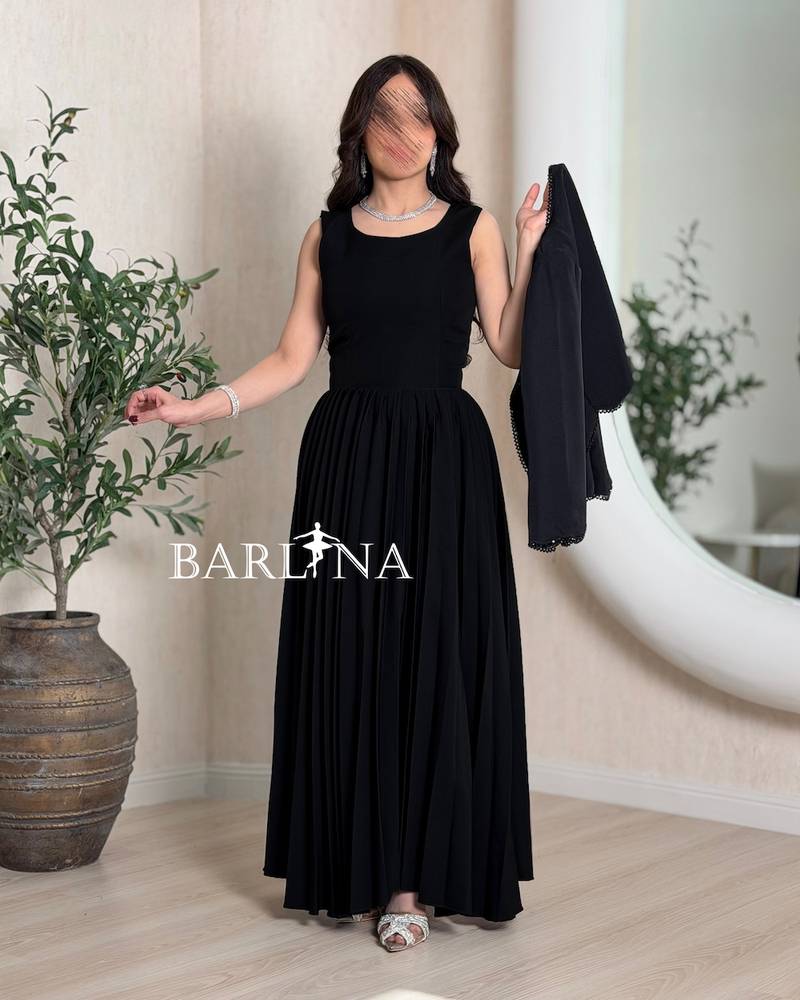 Black pleated dress and embroidered jacket
