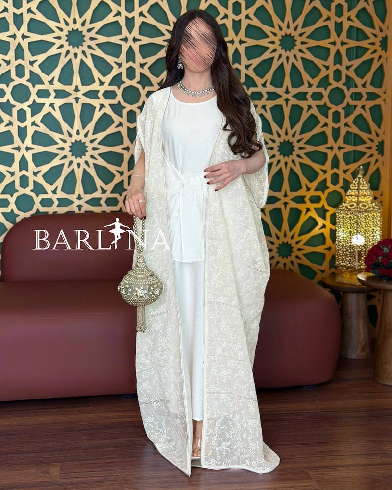 A soft white jalabiya with a sheer lace overlay.