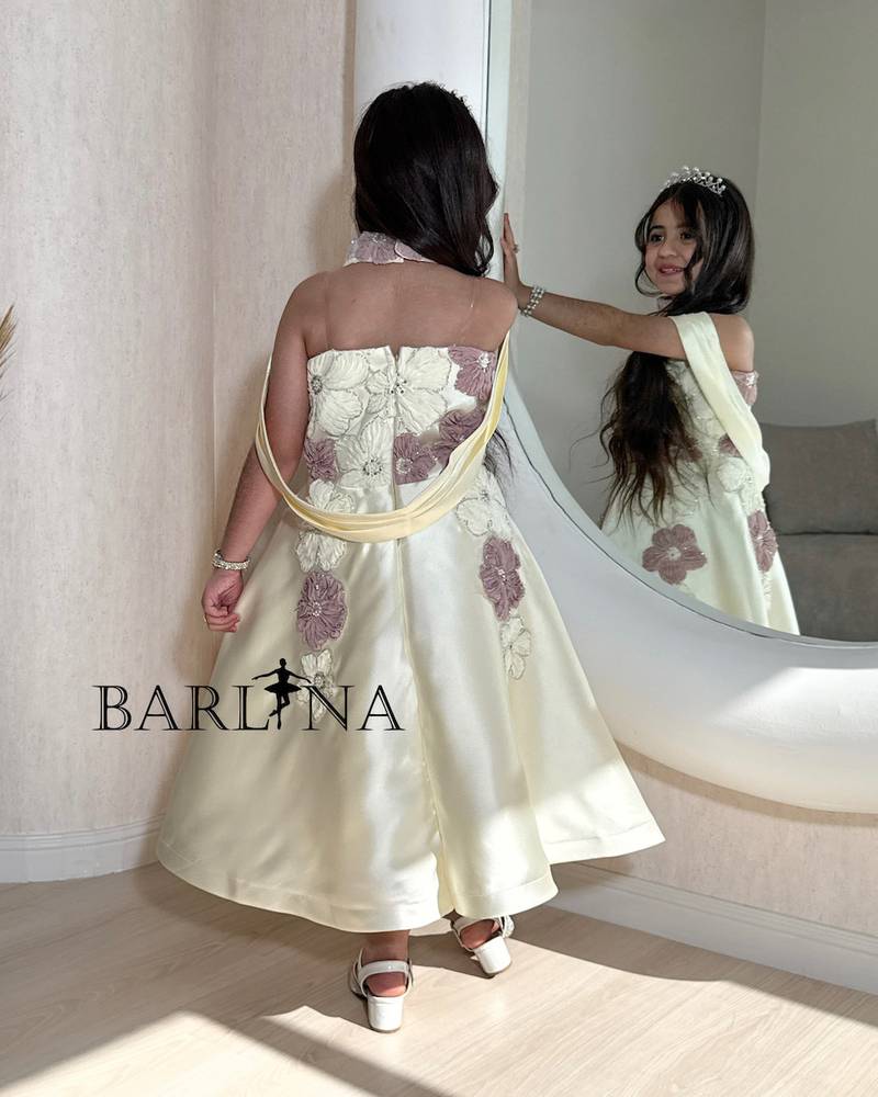 An off-white girl's dress decorated with elegant roses