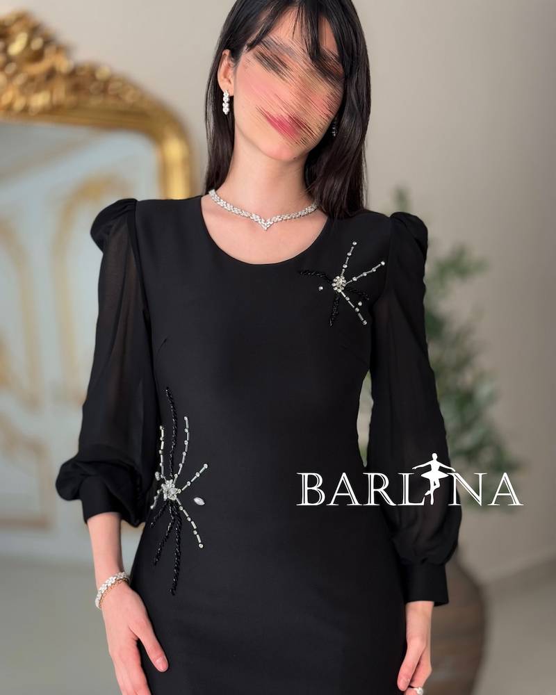 فستان أسود ضيق بأكمام شفافة ناعمة