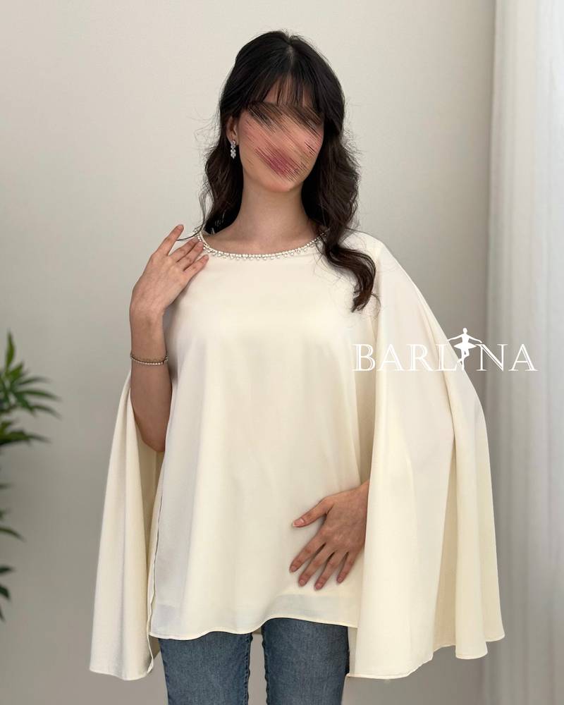 A soft blouse adorned with a pearl trim