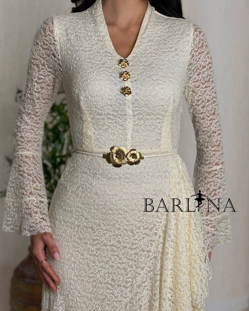 Off-white dress with ruffles at the waist and a gold belt