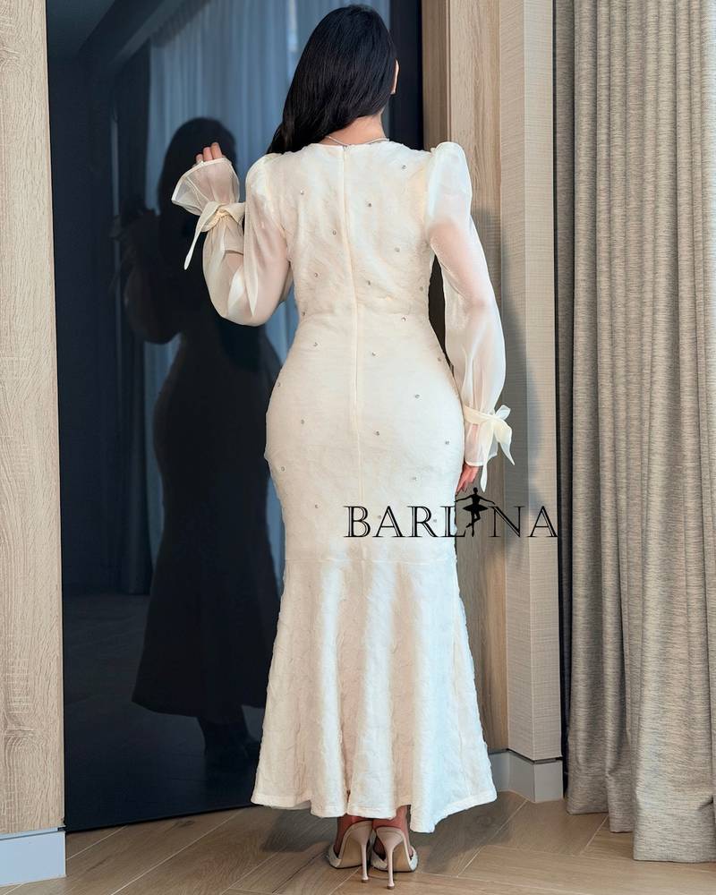 Off-white dress with sheer sleeves and tied cuffs