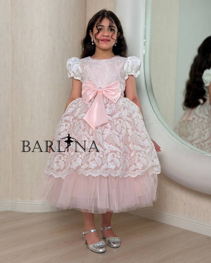 Pink girl's dress decorated with a bow and lace