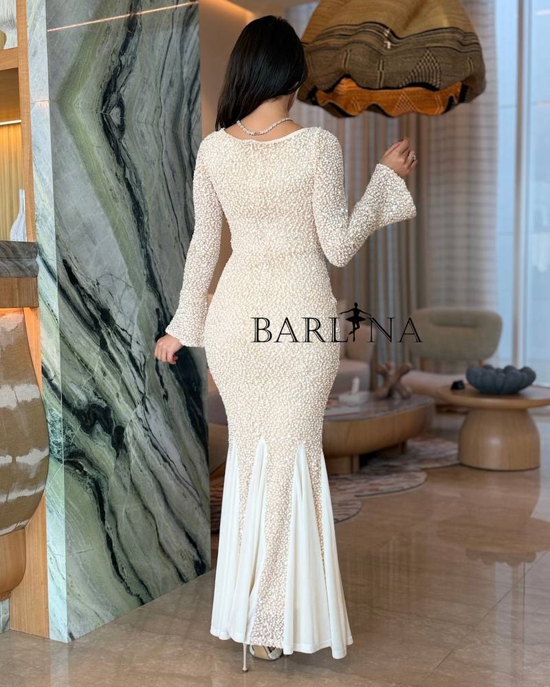 A fitted off-white dress with a flowing mermaid silhouette