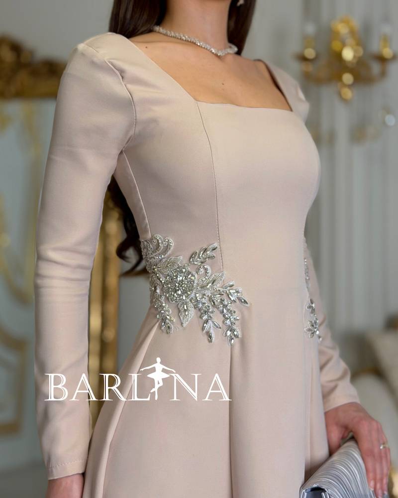 Long beige dress adorned with luxurious embroidery