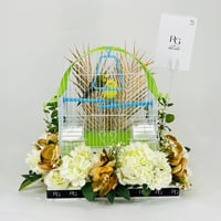 A pair of love birds with a cage decorated with colorful artificial flowers.01 - Image 1