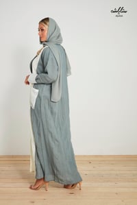 عباية لنن مكسر باللون السماوي والأبيض مزينه بجيوب - صورة 5