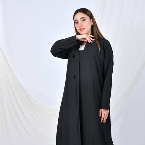 عباية سوداء بتصميم رسمي بسيط بقصة ربع كلوش مزينة بأزرار على شكل زهرة تضيف لمسة أنثوية