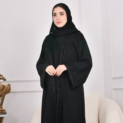 عباية سوداء بكم واسع وفستان متصل مزينة بشك اسود بارز