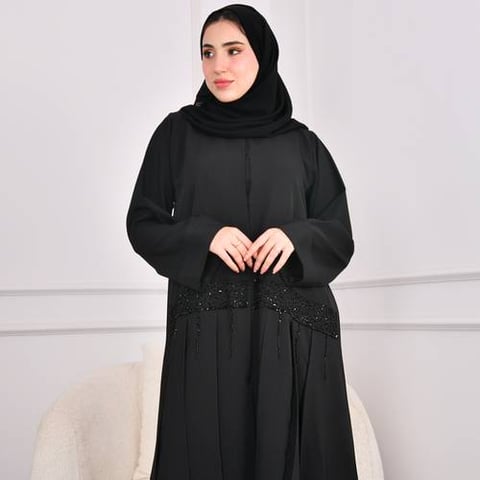 عباية سوداء مغلقة بشك عرضي على العباية و كسرات أسفل في العباية 