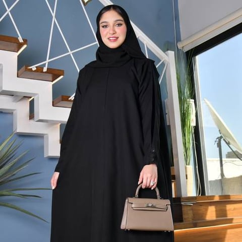 عباية سوداء مغلقة بسحاب اغلاق و ياقة عالية مع أكمام ضيقة مزينة بإزرار 