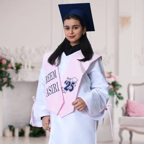 زي التخرج عباية باللون الابيض الناصع بكم عريض مفتوح مزين بفيونكة مع وشاح وكاب سادة باللزن الزهري 