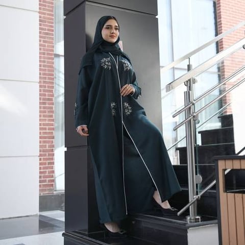 عباية لف باللون الأخضر الداكن مزينة بشك بارز وقيطان على اطراف العباية والاكمام